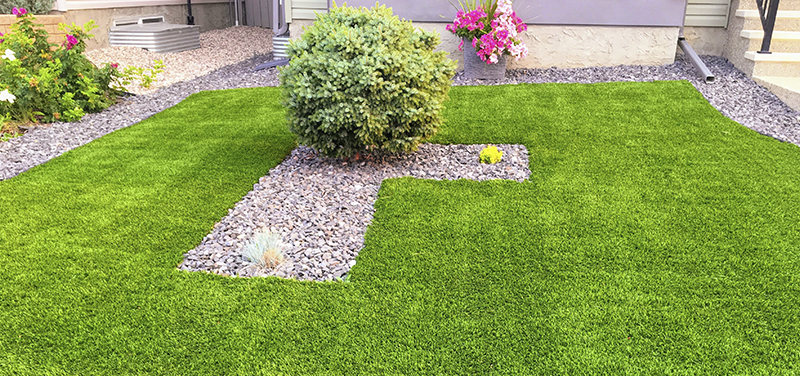 El césped artificial se puede combinar con elementos naturales como piedras decorativas o plantas.