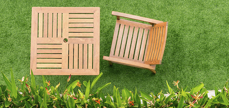 Una buena idea para decorar tu jardín de césped artificial es utilizar mobiliario de madera.
