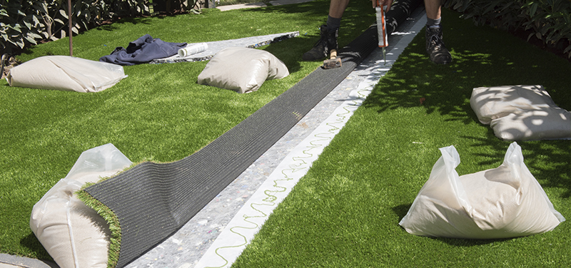 Proceso de instalación de césped artificial en un jardín privado.