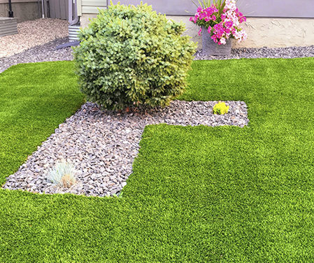 El césped artificial se puede combinar con elementos naturales como piedras decorativas o plantas.