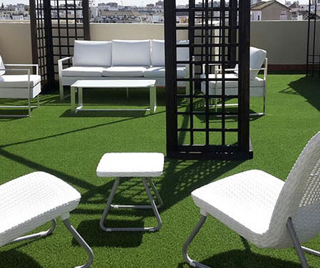 Terraza con césped artificial y muebles modernos